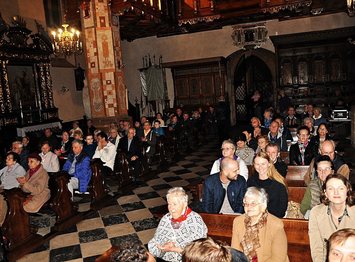 Kilkadziesiąt osób słucha koncertu w kościele