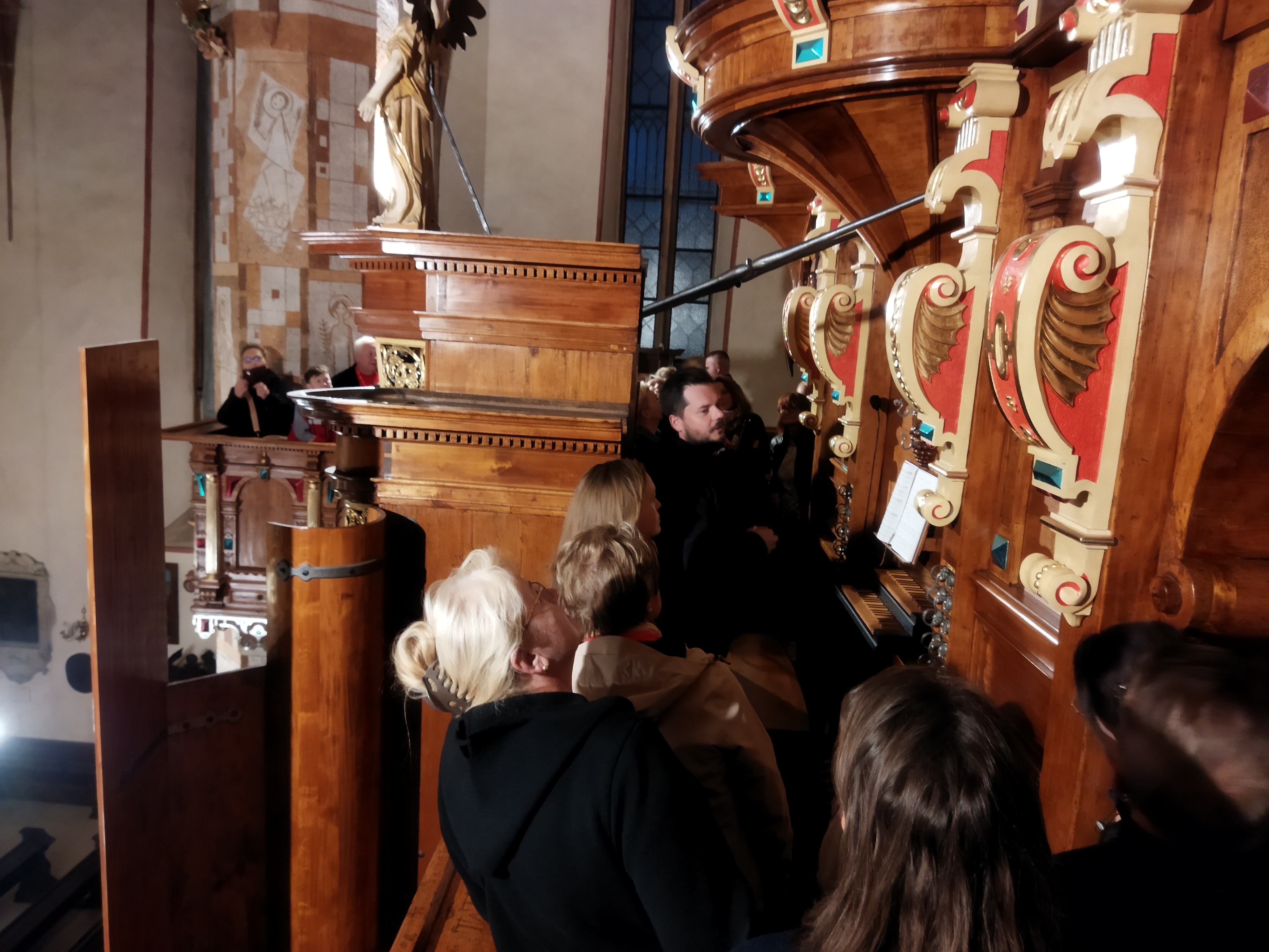 Grupa osób ogląda zabytkowe organy w kościele