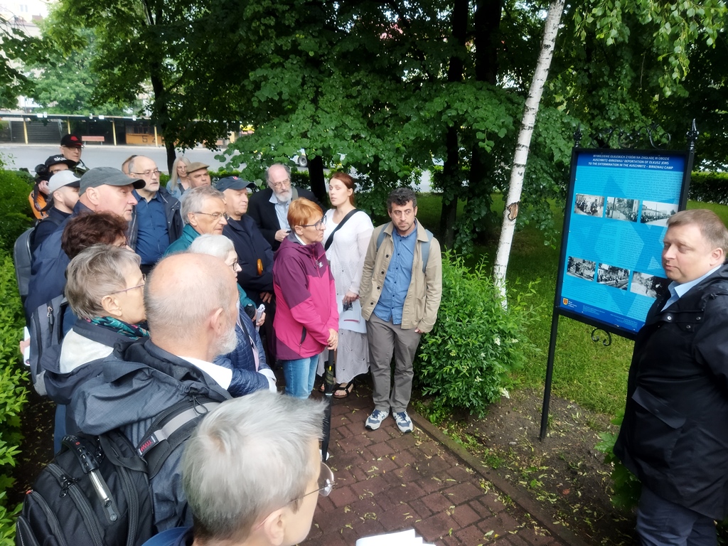 Grupa osób przy tablicy informacyjnej