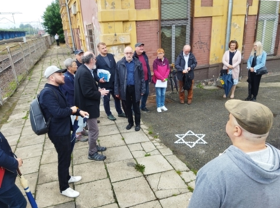 Grupa osób przy stacji kolejowej